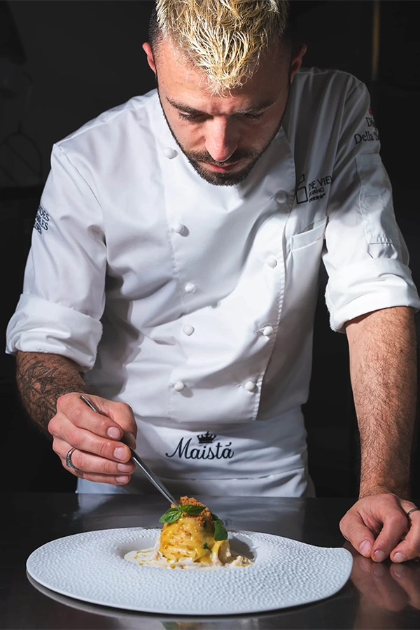 chef impiatta piatto gourmet in cucina professionale maista food