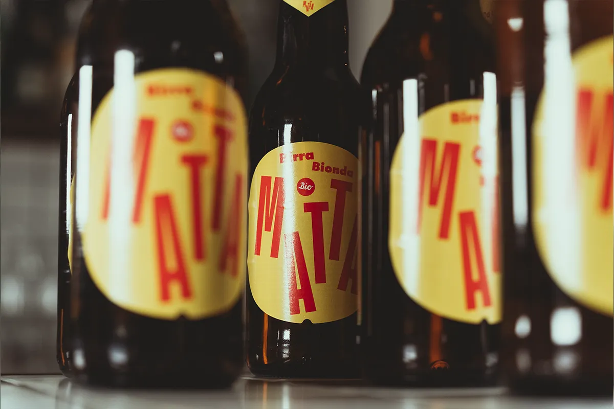 Birra Matta Bisbino in primo piano con etichetta su bottiglie allineate