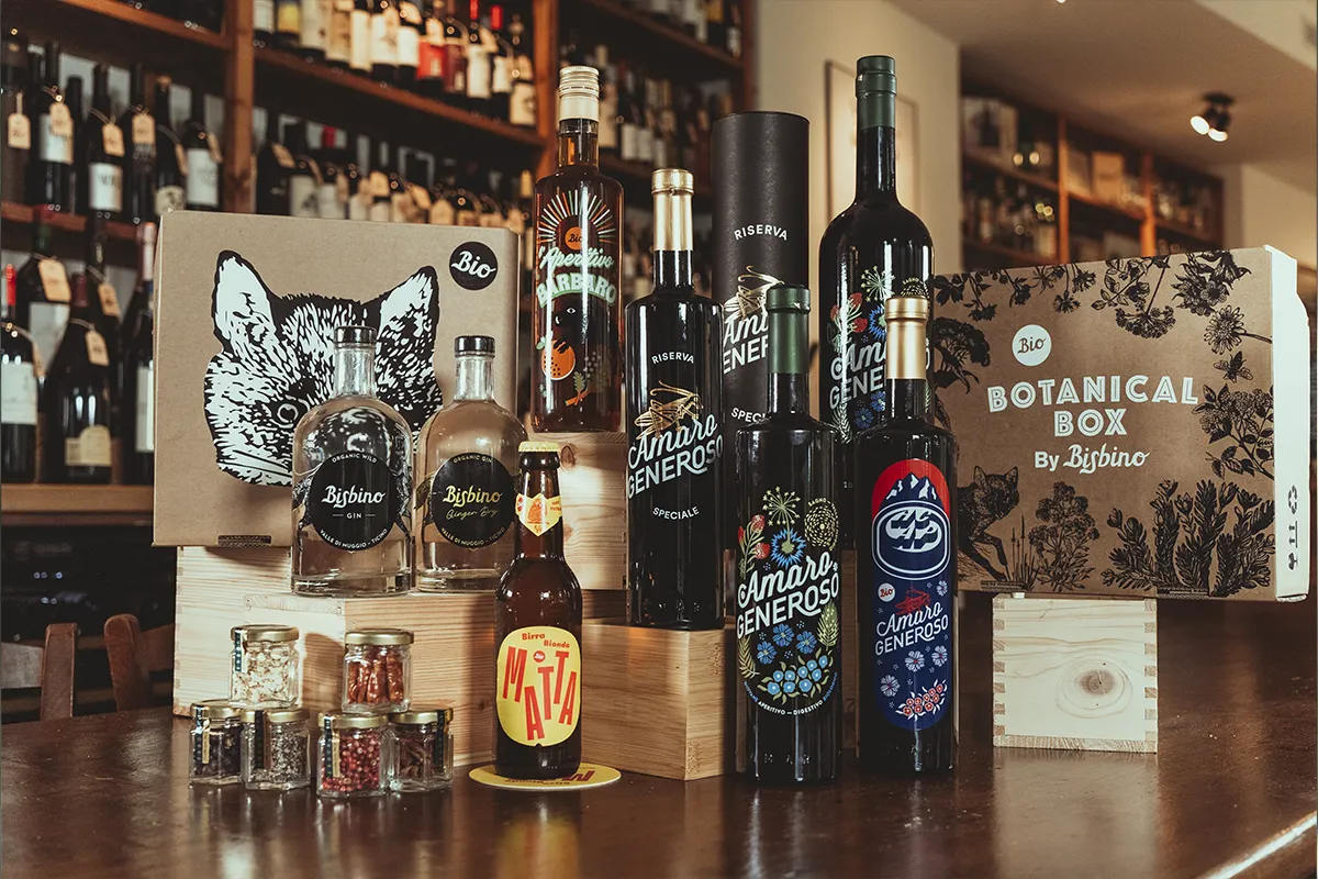 Gamma prodotti Bisbino con gin, amaro e birra su banco bar con packaging brandizzato