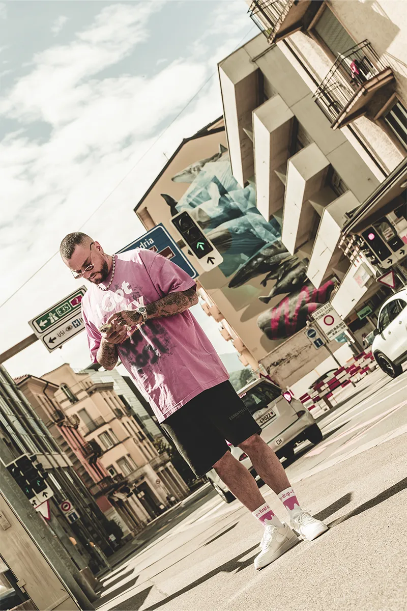 Guè rapper italiano con calzini Drip rosa per le strade del Ticino