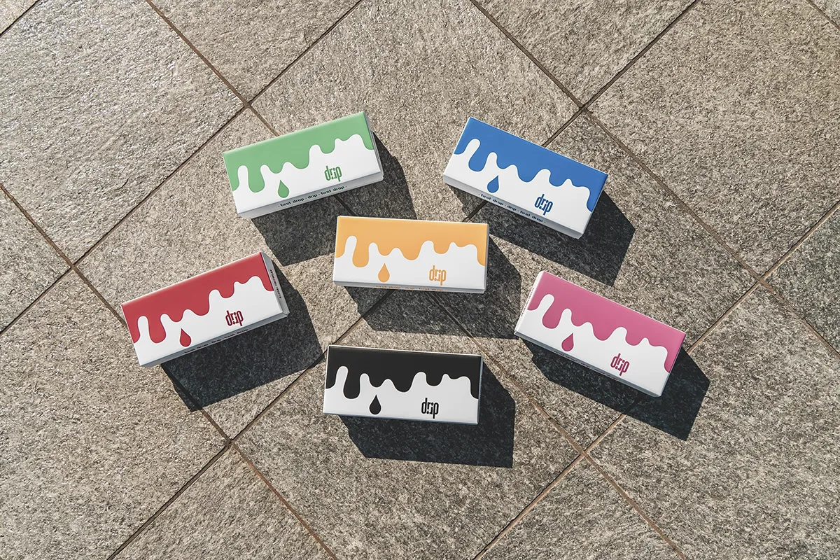 Packaging calze Drip con scatole colorate su superficie urbana