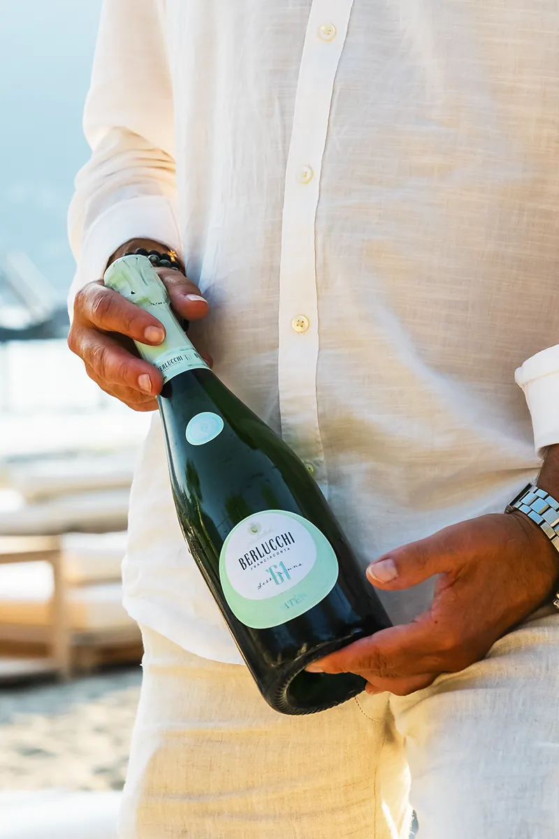 Bottiglia Berlucchi Franciacorta tenuta in mano evento lago Borgovecchio