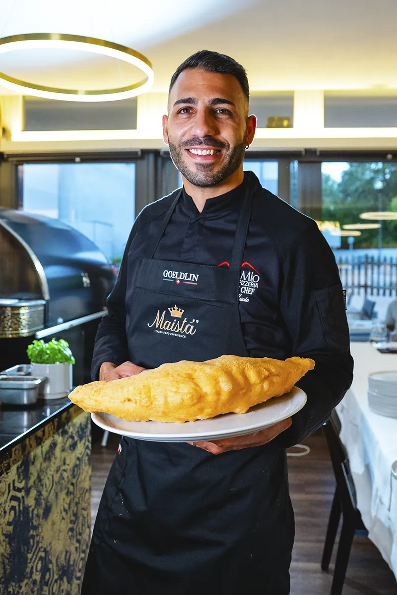 Chef pizzaiolo Core Mio regge calzone fritto sala ristorante Lugano